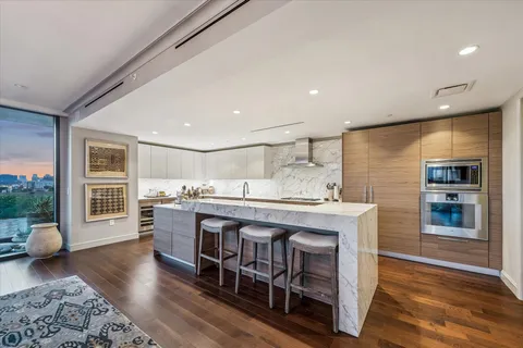 a kitchen with stainless steel appliances granite countertop a kitchen island hardwood floor sink stove and granite counter top