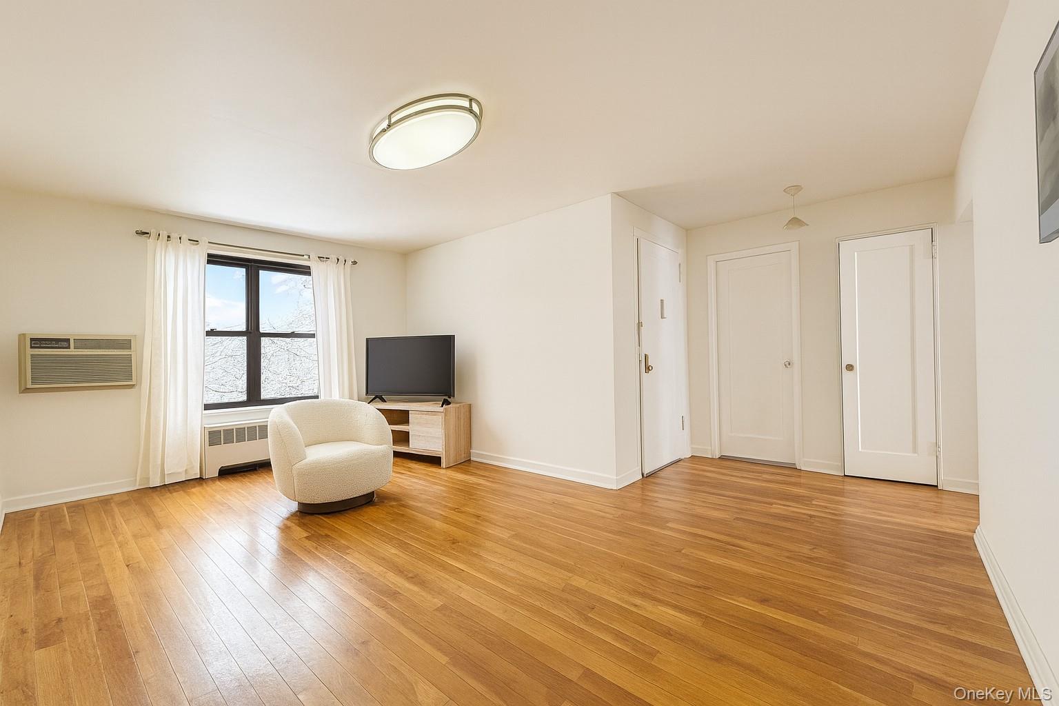 7 Terrace Circle, Unit 3D Great Neck, NY 11021 - Photo 4 of 31 a living room with furniture wooden floor and a flat screen tv