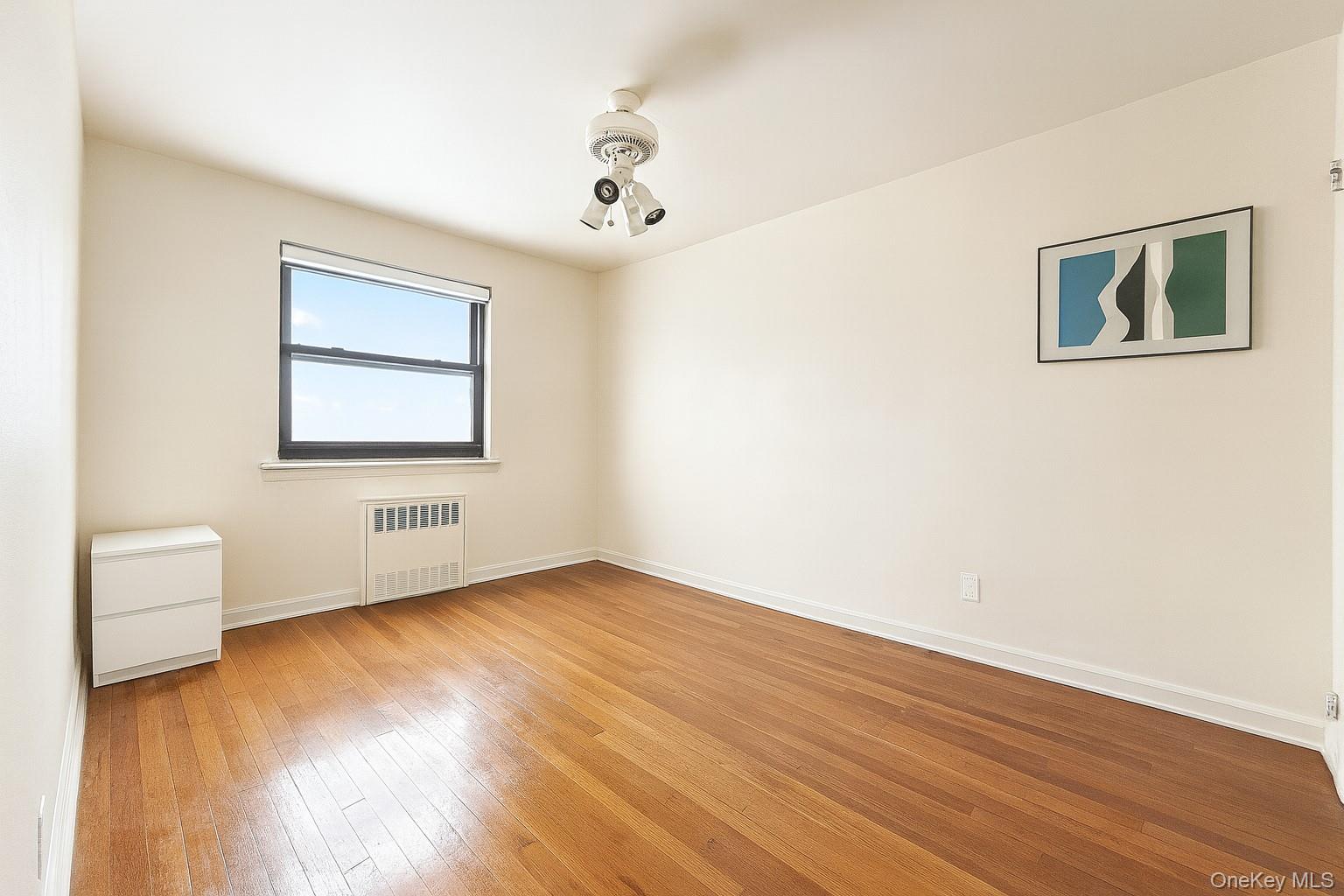 7 Terrace Circle, Unit 3D Great Neck, NY 11021 - Photo 6 of 31 a view of an empty room with wooden floor and a window