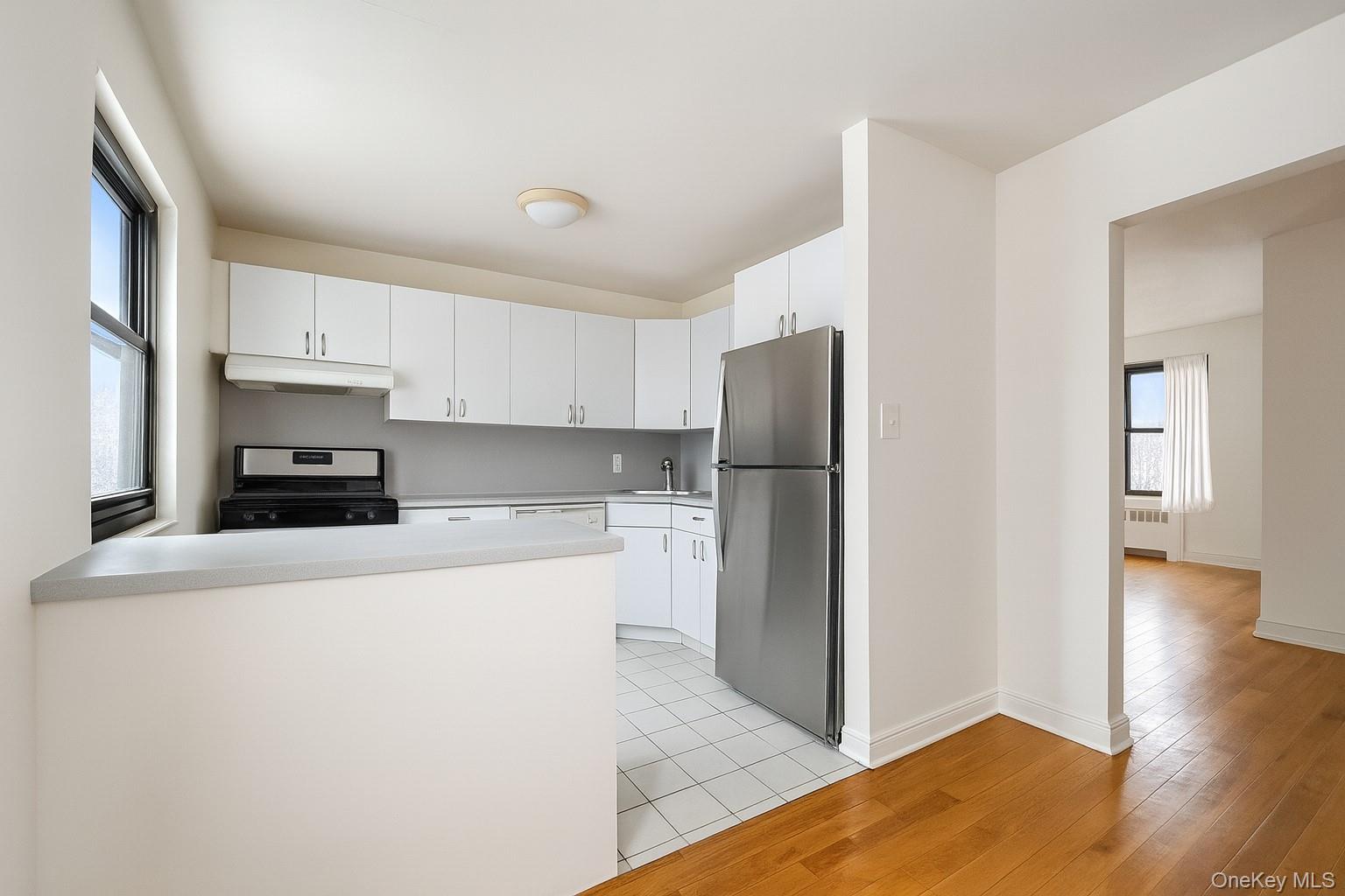 7 Terrace Circle, Unit 3D Great Neck, NY 11021 - Photo 10 of 31 a kitchen with a refrigerator and a stove top oven