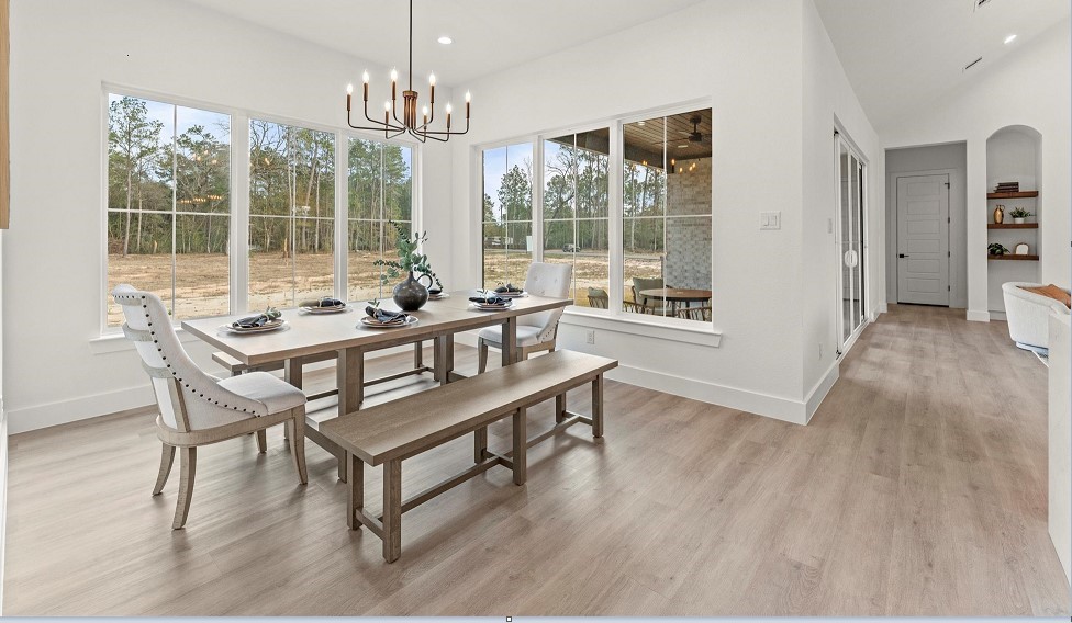 15045 Tybee Lane Conroe, TX 77306 - Photo 2 of 41 a dining room with furniture a chandelier and wooden floor