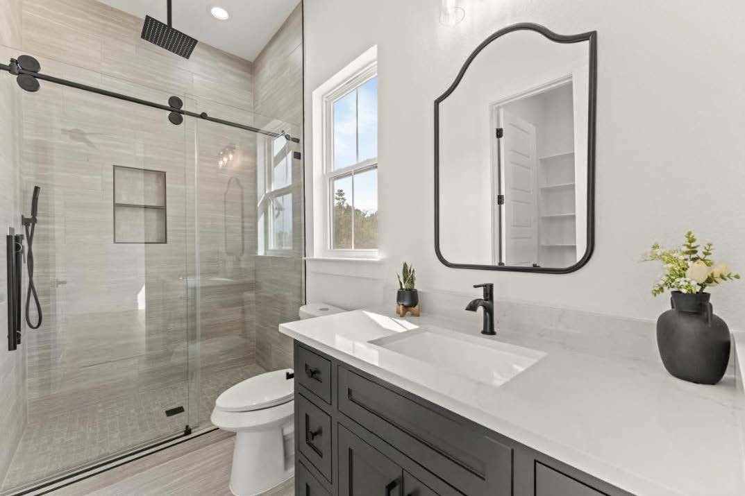 15045 Tybee Lane Conroe, TX 77306 - Photo 28 of 41 a bathroom with a granite countertop sink a toilet and shower