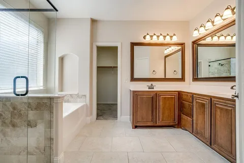 a spacious bathroom with a sink a mirror and a bathtub