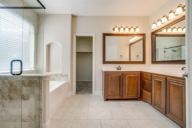 a spacious bathroom with a sink a mirror and a bathtub