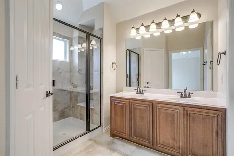 a bathroom with double vanity and a mirror