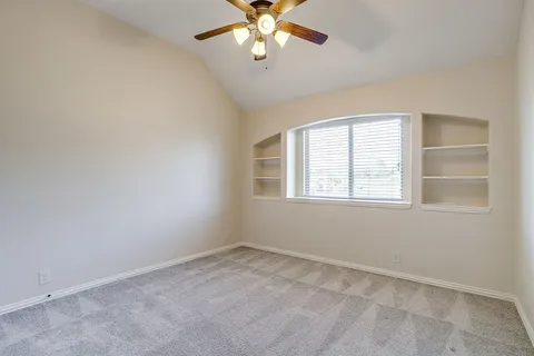 an empty room with a window and a fan