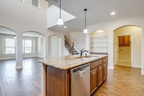 a kitchen with a sink a chandelier and living room view