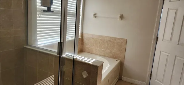 an empty room with windows and a ceiling fan