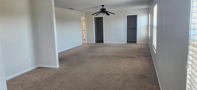 a view of a hallway with wooden floor and entryway