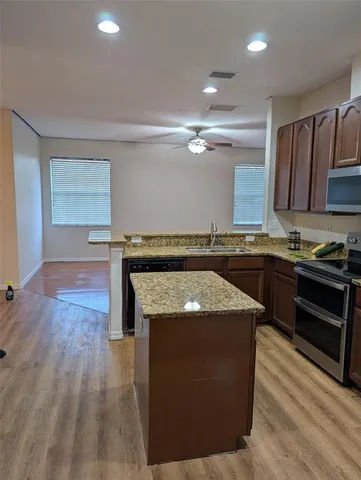 a kitchen with granite countertop a sink and a stove top oven
