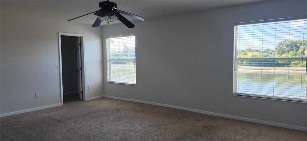 7524 Dragon Fly Loop Gibsonton, FL 33534 - Photo 42 of 55 an empty room with windows and a ceiling fan