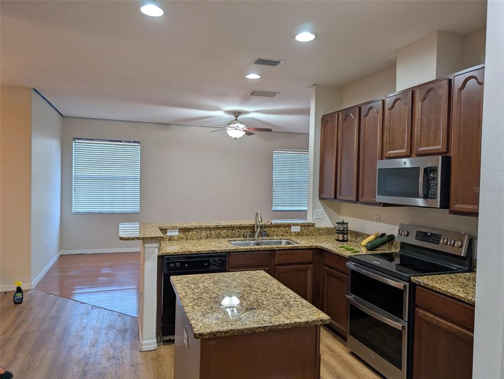 7524 Dragon Fly Loop Gibsonton, FL 33534 - Photo 6 of 55 a kitchen with granite countertop stainless steel appliances and wooden cabinets