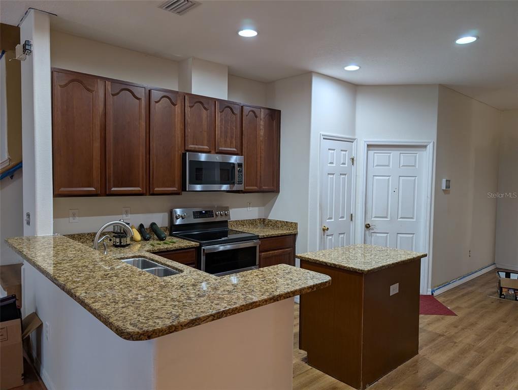 7524 Dragon Fly Loop Gibsonton, FL 33534 - Photo 10 of 55 a kitchen with stainless steel appliances granite countertop a sink stove and refrigerator