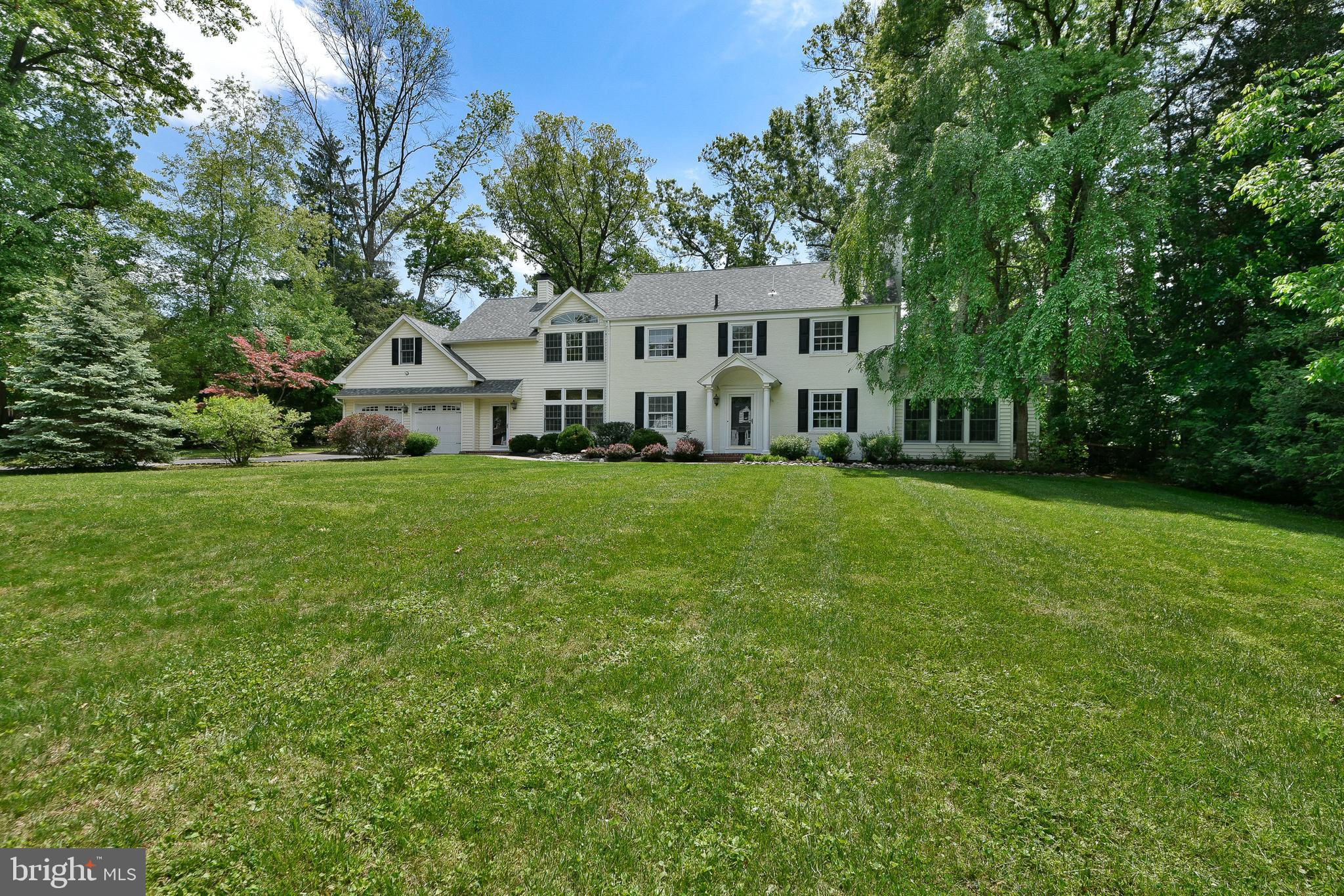 a view of a house with a big yard and large trees