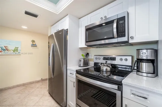 a kitchen with stainless steel appliances granite countertop a stove microwave and refrigerator