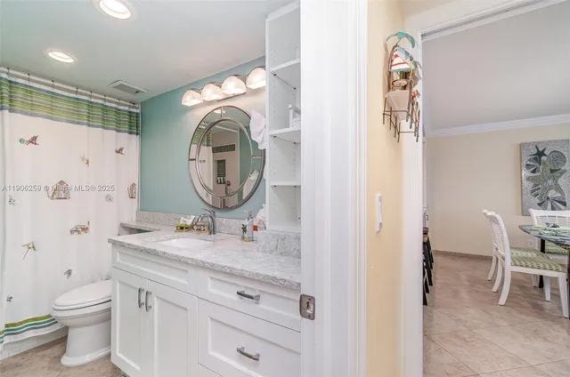 a bathroom with a granite countertop toilet a sink and a mirror