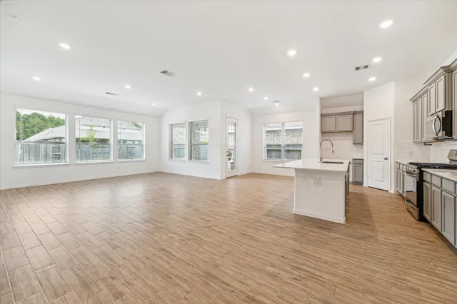 a view of kitchen with stainless steel appliances refrigerator oven and cabinets