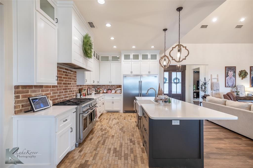 622 Ranch Road Buffalo Gap, TX 79508 - Photo 11 of 40 a large kitchen with stainless steel appliances granite countertop a sink a stove and a wooden floors