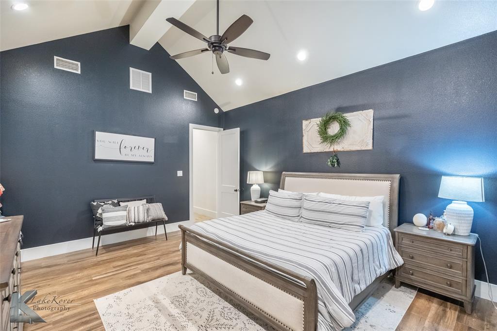 622 Ranch Road Buffalo Gap, TX 79508 - Photo 17 of 40 a bedroom with a bed and a chandelier