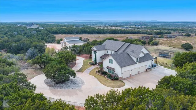 an aerial view of a house with a yard and lake view