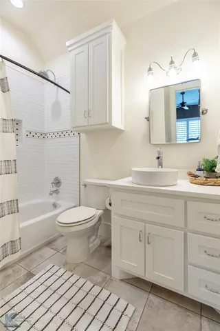 a bathroom with a toilet a sink a mirror a bathtub and vanity