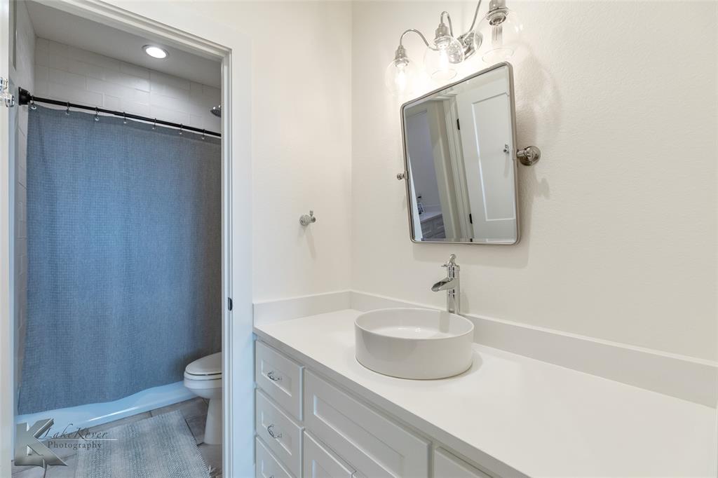 622 Ranch Road Buffalo Gap, TX 79508 - Photo 26 of 40 a bathroom with a sink toilet and shower