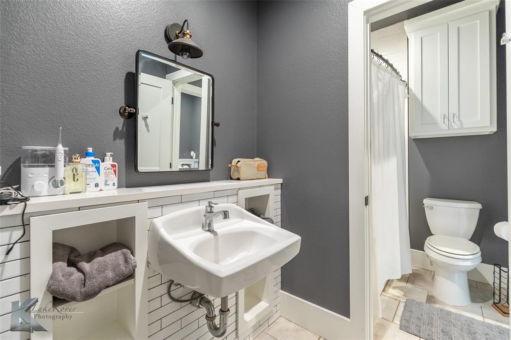 622 Ranch Road Buffalo Gap, TX 79508 - Photo 29 of 40 a bathroom with a sink a toilet and mirror