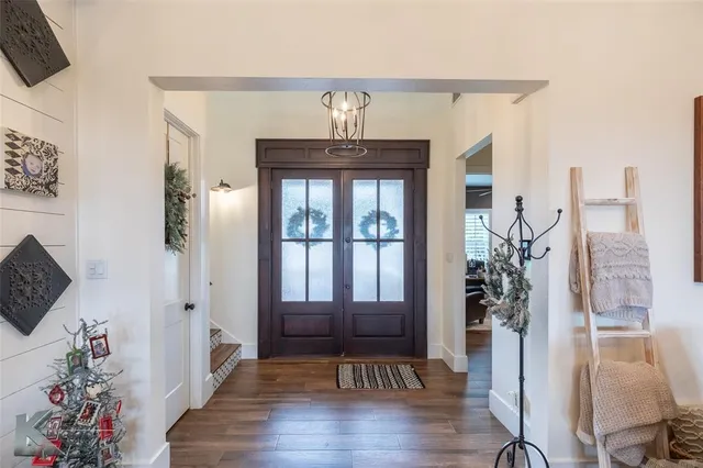 a view of a hallway with wooden floor and a potted plant