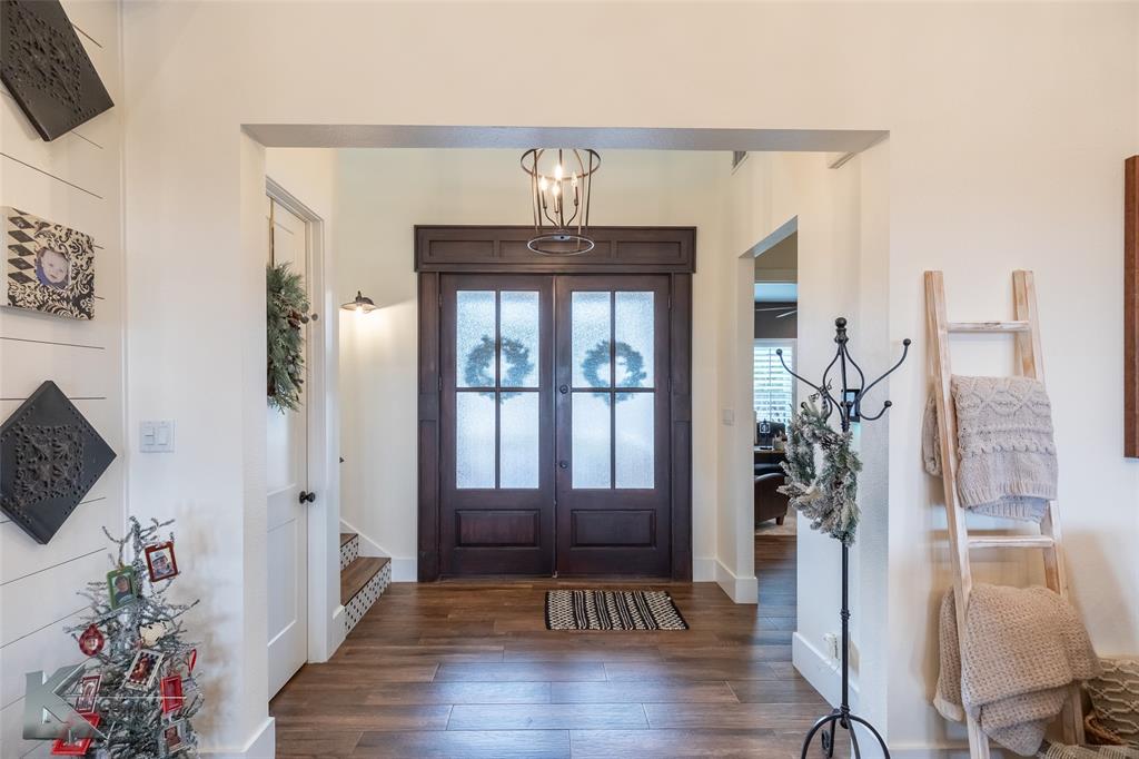 622 Ranch Road Buffalo Gap, TX 79508 - Photo 4 of 40 a view of a hallway with wooden floor and a potted plant