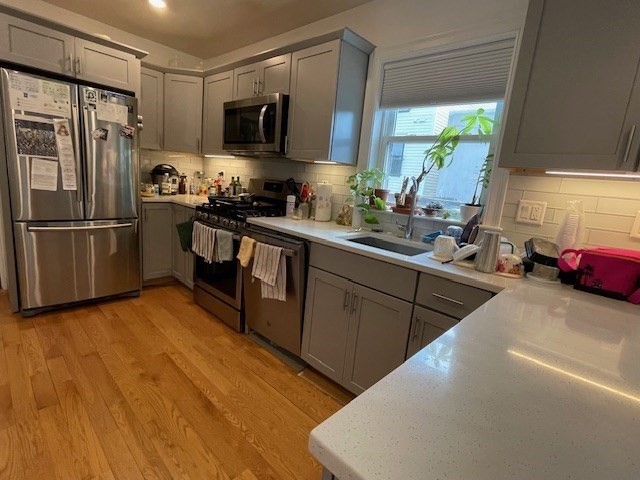6 Beech Street, Unit 3 Cambridge, MA 02140 - Photo 2 of 16 a kitchen with stainless steel appliances granite countertop a refrigerator a sink a stove a microwave a counter space and cabinets