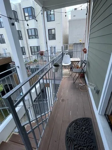 a view of a balcony with furniture and wooden floor