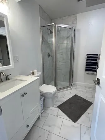 a bathroom with a sink a toilet a mirror and shower