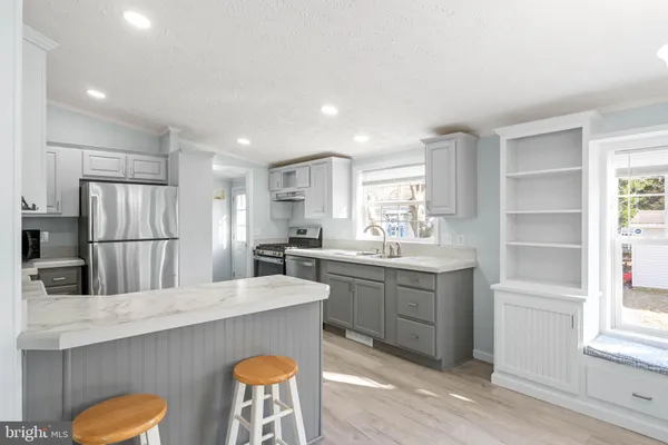 a kitchen with stainless steel appliances a sink stove and refrigerator