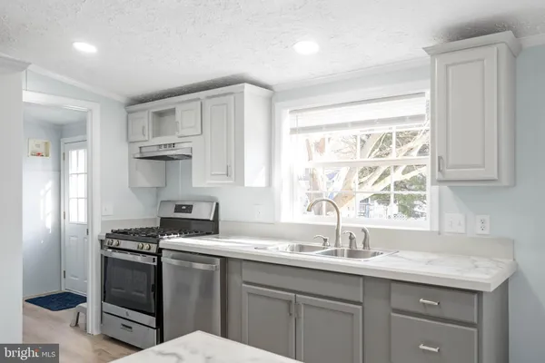 a kitchen with a refrigerator a sink and a stove top oven