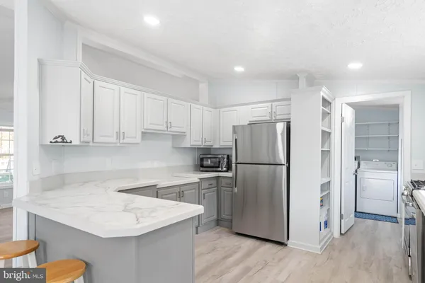 a kitchen with cabinets and wooden floor