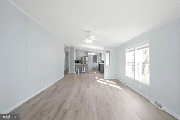 a view of an empty room with window and wooden floor