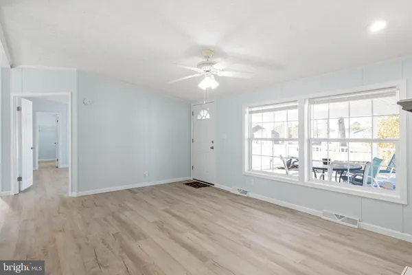an empty room with windows fireplace and wooden floor
