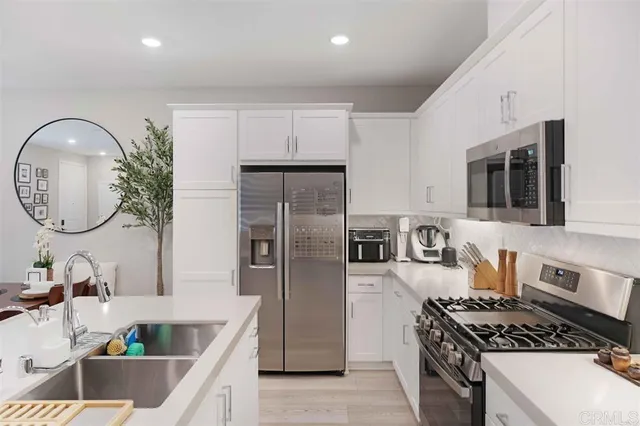 a kitchen with stainless steel appliances granite countertop a stove a refrigerator a sink and a microwave