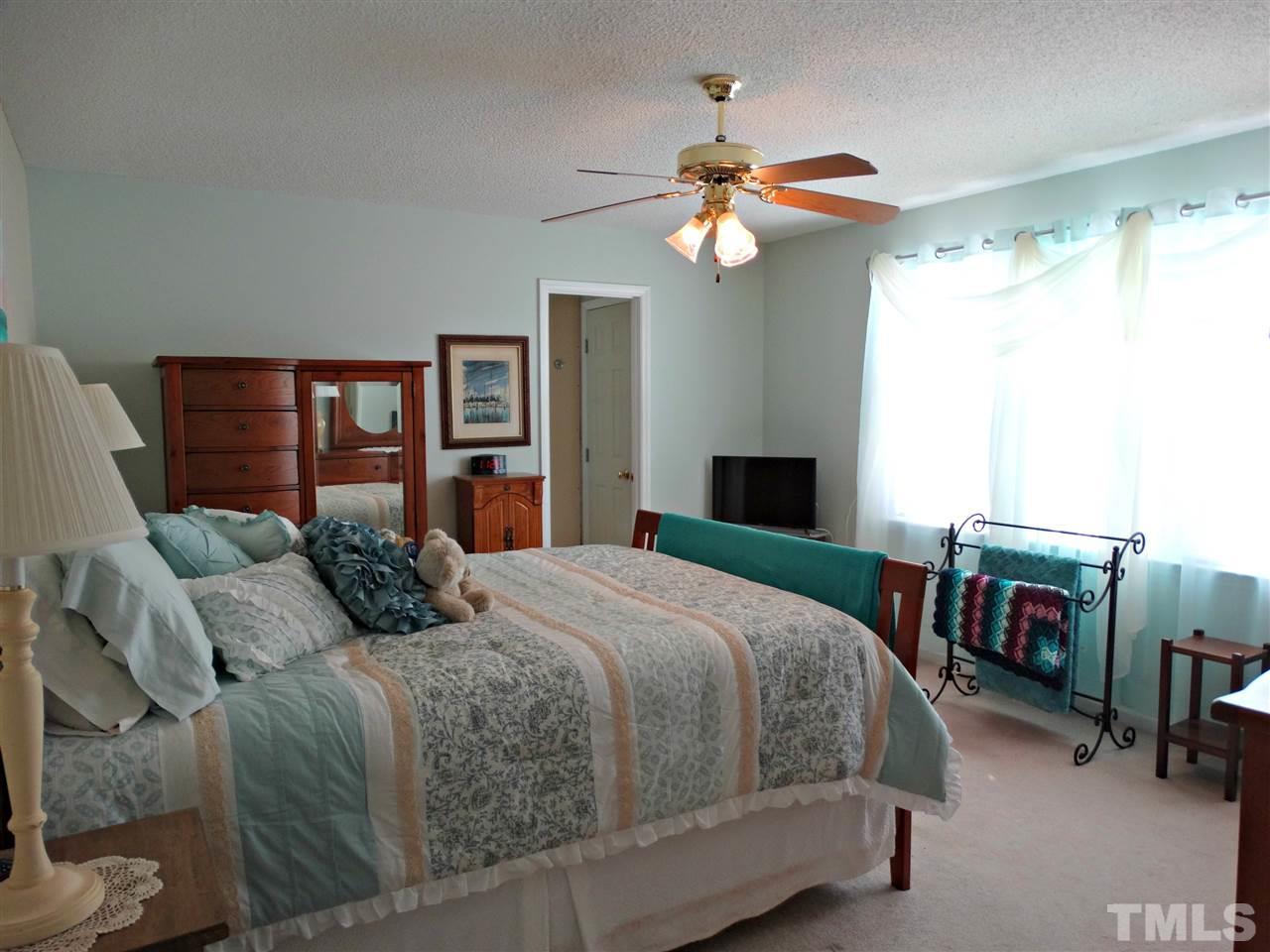 4916 Topstone Road Raleigh, NC 27603 - Photo 15 of 25 a bedroom with a bed and a chandelier