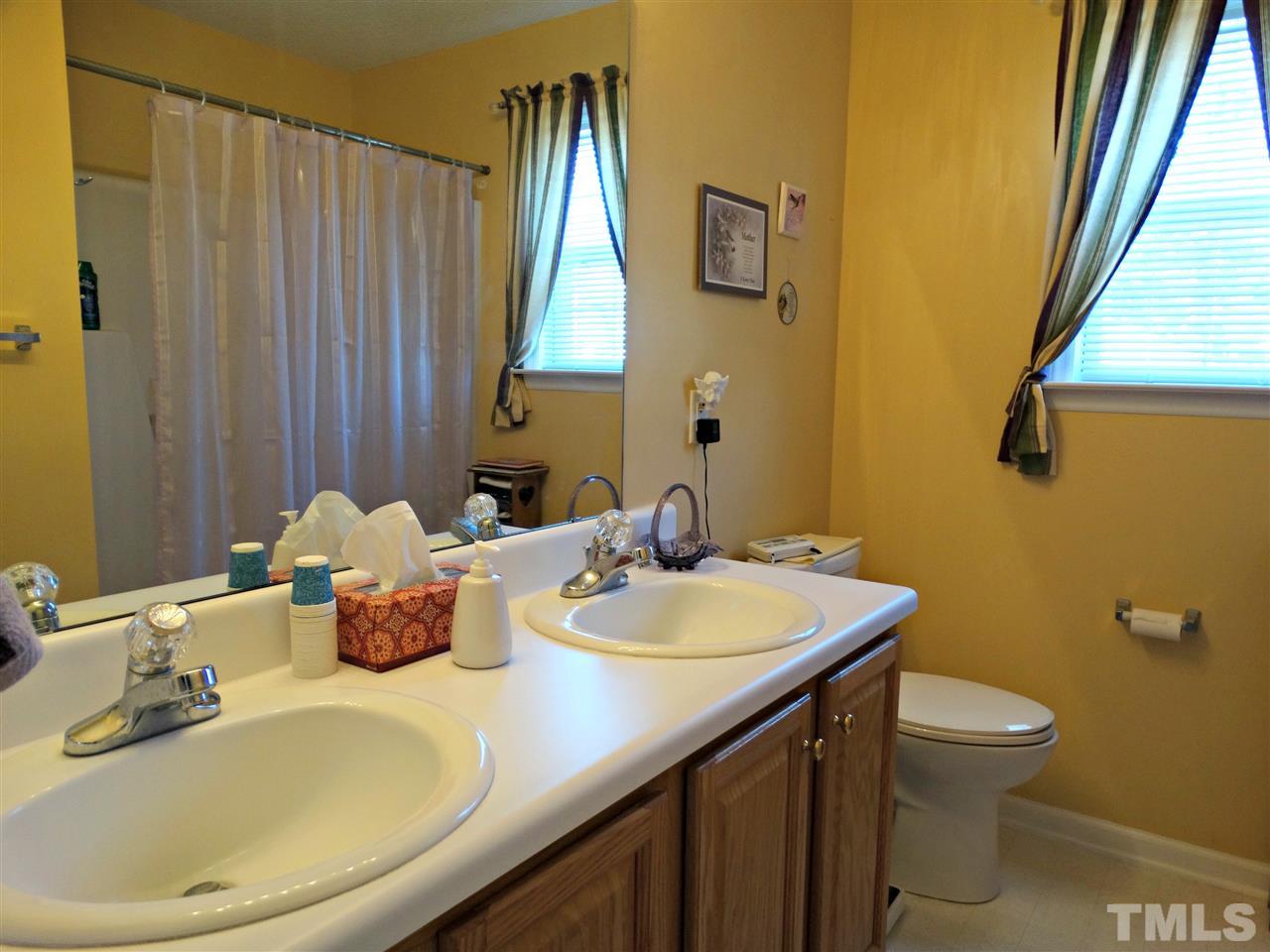4916 Topstone Road Raleigh, NC 27603 - Photo 19 of 25 a bathroom with a sink a toilet and a mirror
