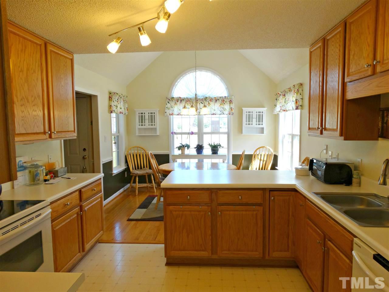 4916 Topstone Road Raleigh, NC 27603 - Photo 7 of 25 a kitchen with stainless steel appliances a sink stove and cabinets