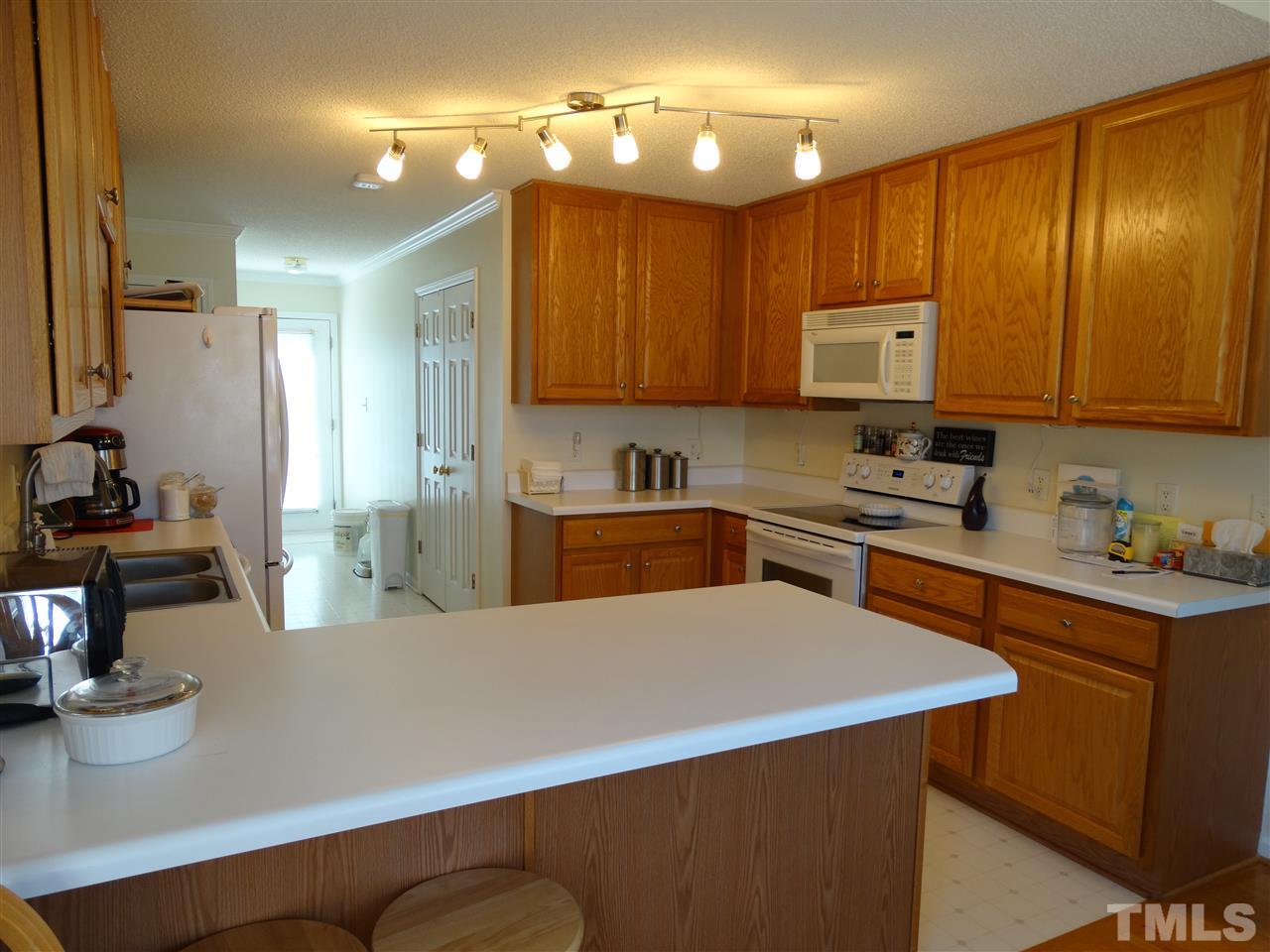 4916 Topstone Road Raleigh, NC 27603 - Photo 8 of 25 a kitchen with stainless steel appliances a sink a stove a refrigerator cabinets and a counter top space