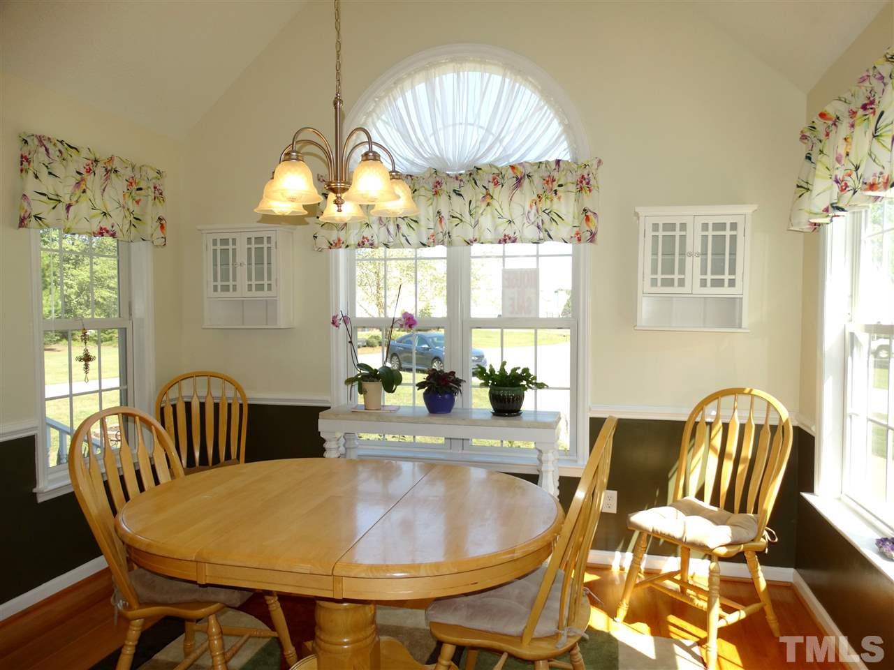 4916 Topstone Road Raleigh, NC 27603 - Photo 9 of 25 a dining room with furniture a chandelier and wooden floor