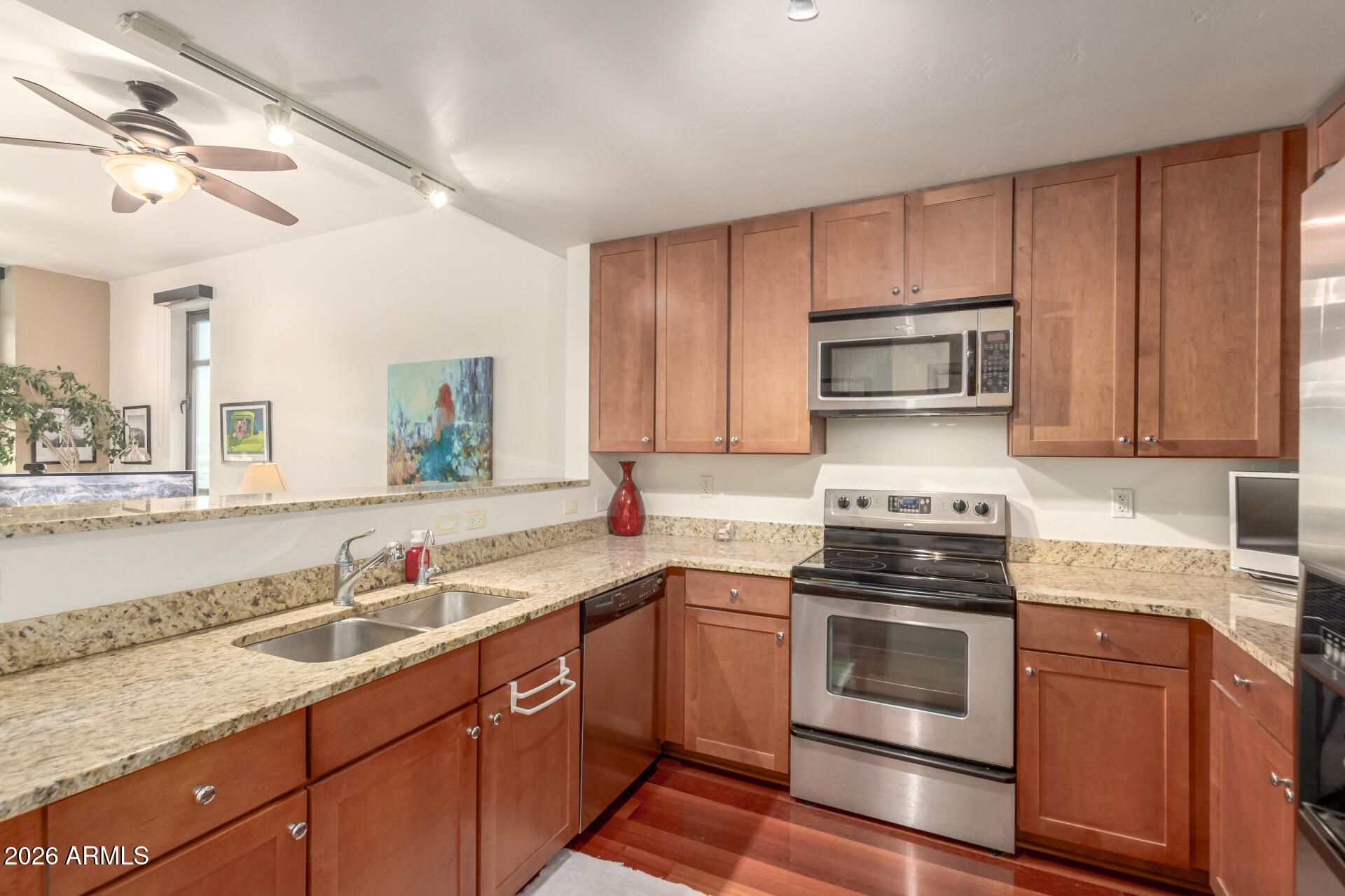 310 South 4th Street, Unit 1109 Phoenix, AZ 85004 - Photo 11 of 36 a kitchen with kitchen island granite countertop a sink stainless steel appliances and cabinets