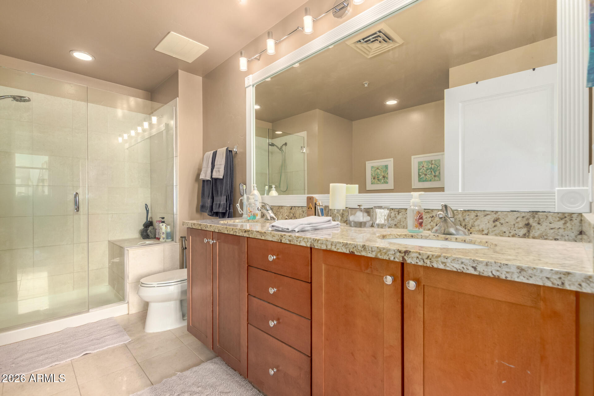 310 South 4th Street, Unit 1109 Phoenix, AZ 85004 - Photo 19 of 36 a bathroom with a granite countertop sink a toilet a mirror and shower