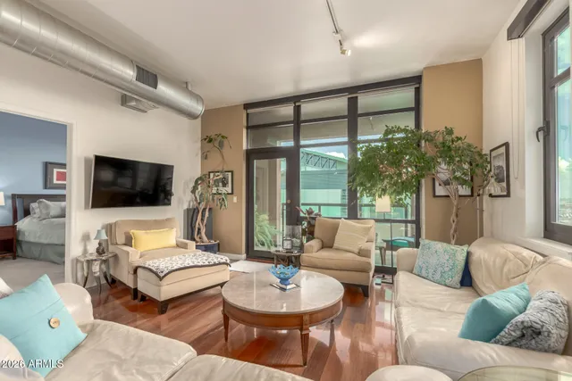 a living room with furniture a flat screen tv and kitchen view