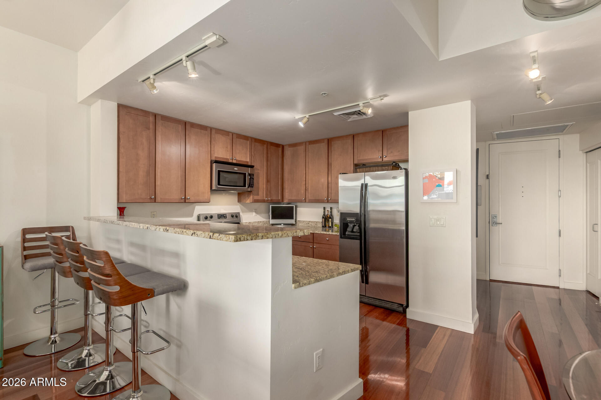 310 South 4th Street, Unit 1109 Phoenix, AZ 85004 - Photo 9 of 36 a kitchen with stainless steel appliances granite countertop a refrigerator a stove top oven a sink dishwasher and wooden cabinets