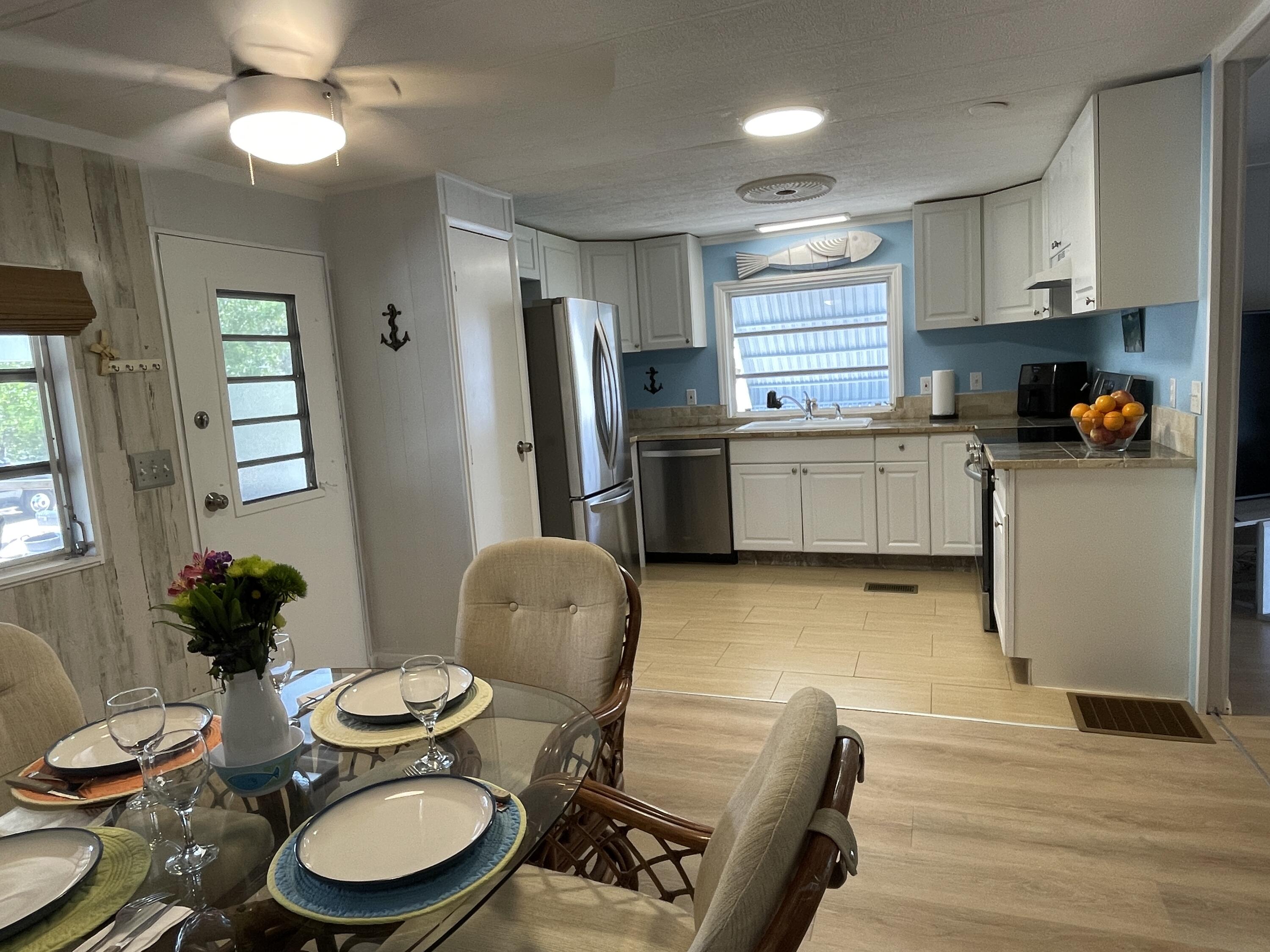 27853 Coral Shores Road Summerland Key, FL 33042 - Photo 13 of 47 a kitchen with sink refrigerator dining table and chairs