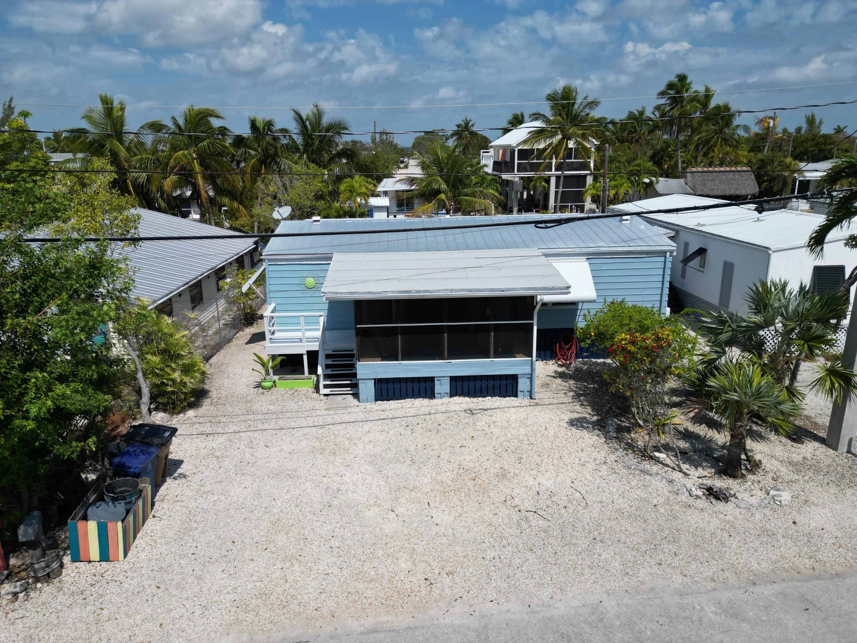 27853 Coral Shores Road Summerland Key, FL 33042 - Photo 5 of 47 a front view of a house with a yard and garage