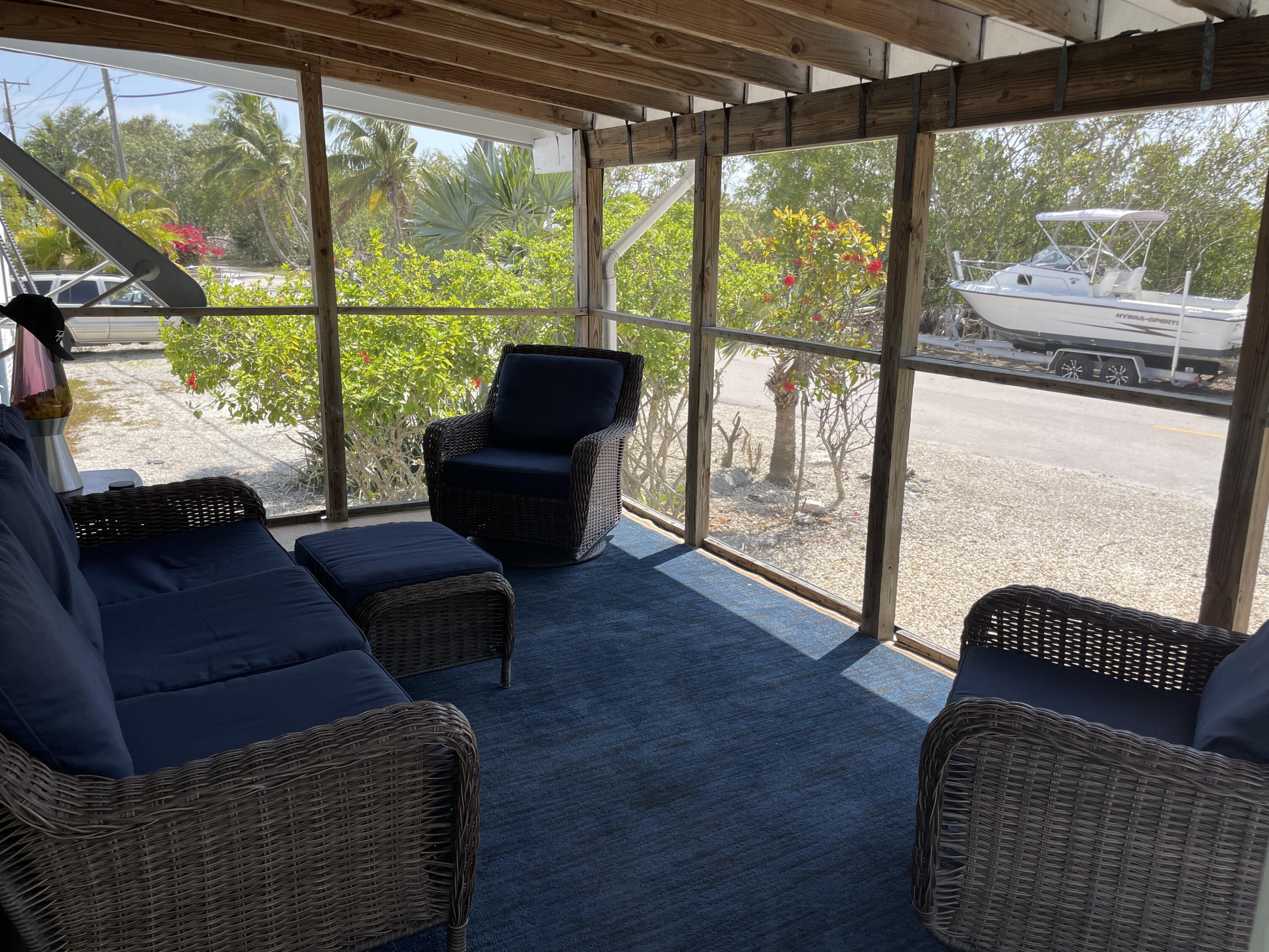 27853 Coral Shores Road Summerland Key, FL 33042 - Photo 10 of 47 a living room with couch and a floor to ceiling window